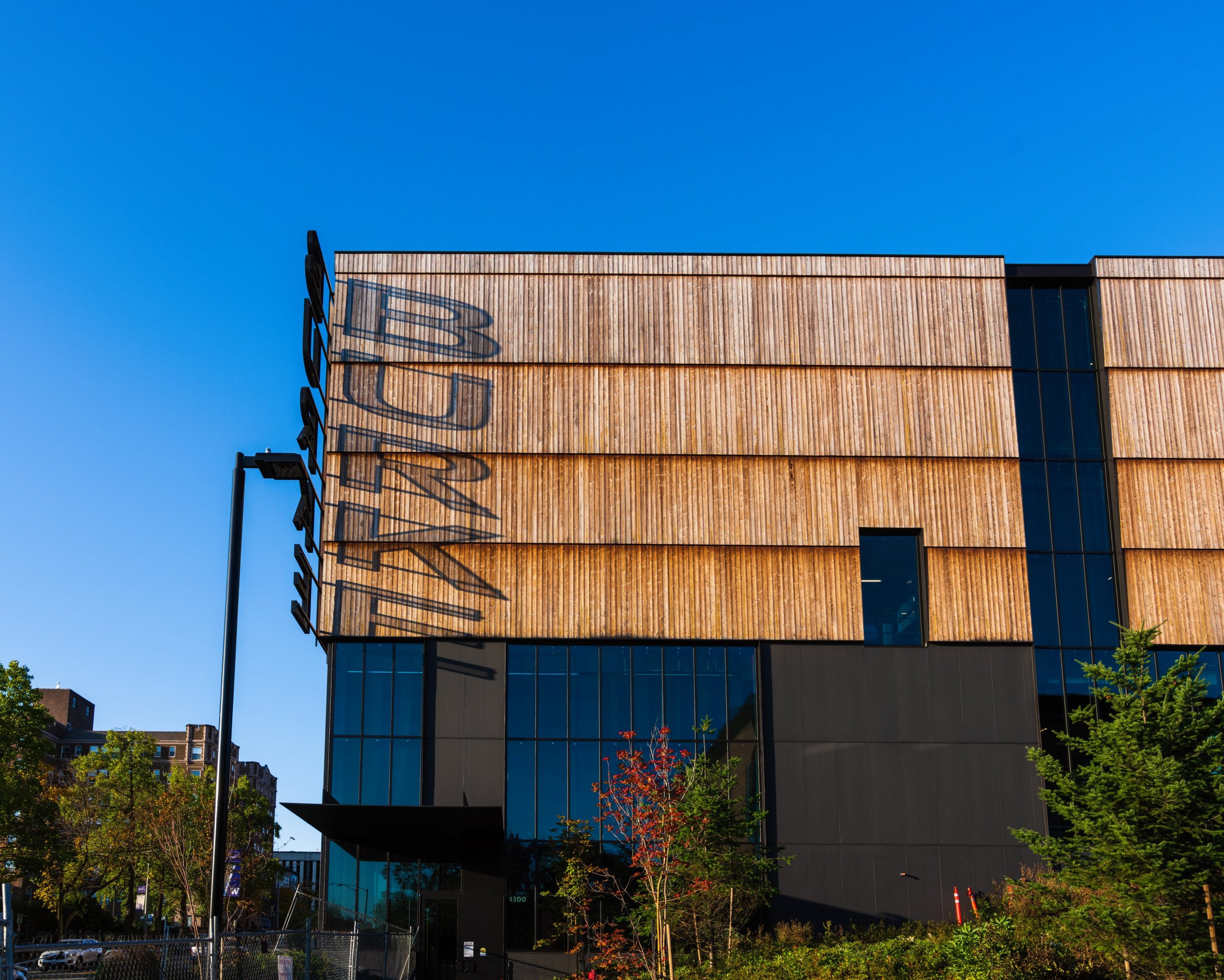 Edge of the Burke Museum of Natural History's exterior walls featuring Kebony Modified Wood Character Cladding in Seattle, Washington during a sunset and bright blue sky