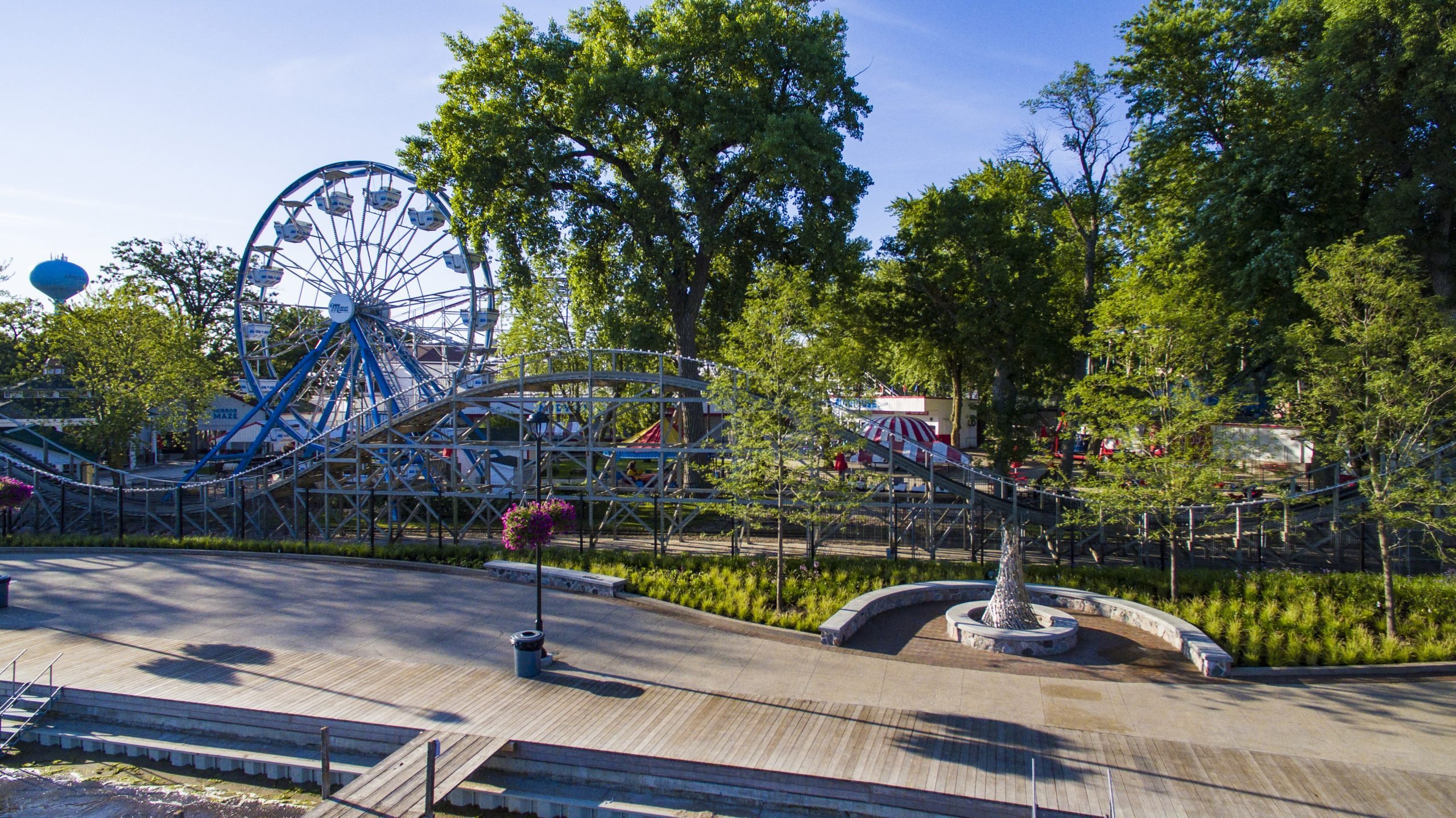 Side view of the amusement rides area at the Arnolds Park State Pier & Boardwalk on a sunny day featuring Kebony Modified Wood Clear Boardwalk Decking in Arnolds Park, Indiana