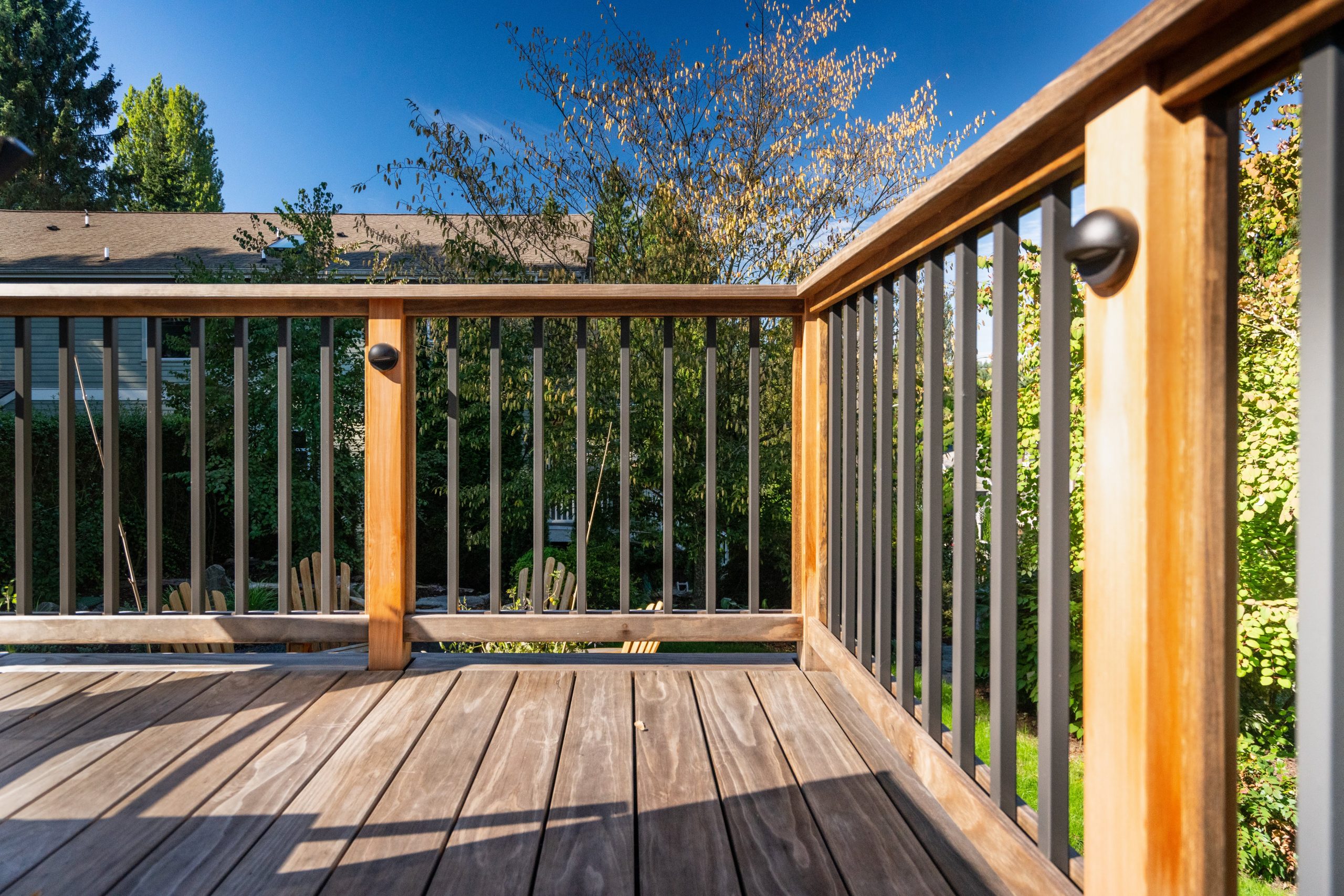 View of the back patio deck featuring Kebony Modified Wood Clear Decking at this residential project in Seattle, Washington with trees in the background on a sunny day