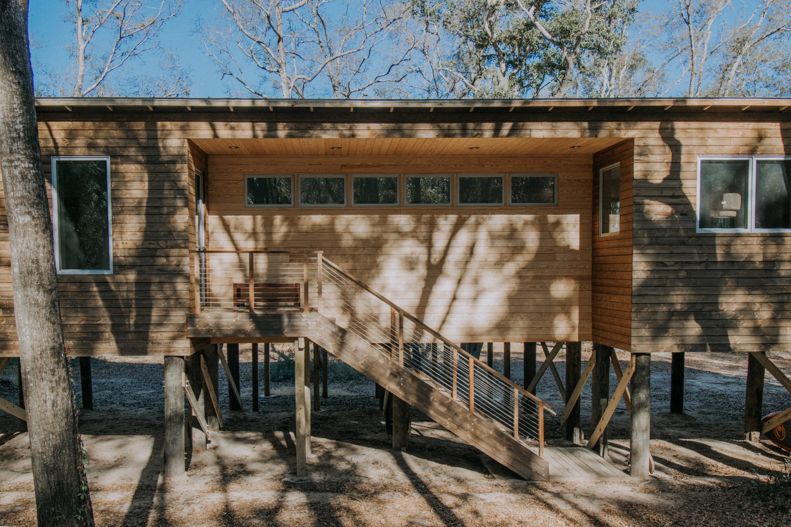 Closer view of the Bohicket House family residence in Johns Island, South Carolina that features Kebony Modified Wood Character Cladding and is surrounded by a wooded area on a sunny day