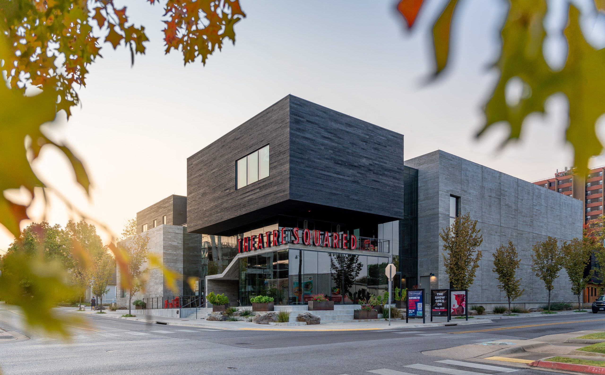 Outside three-quarter street view of Theatre Squared professional theatre in Fayetteville, Arkansas during a sunset featuring Kebony Clear Cladding with a Shou Sugi Ban Half Gator Finish