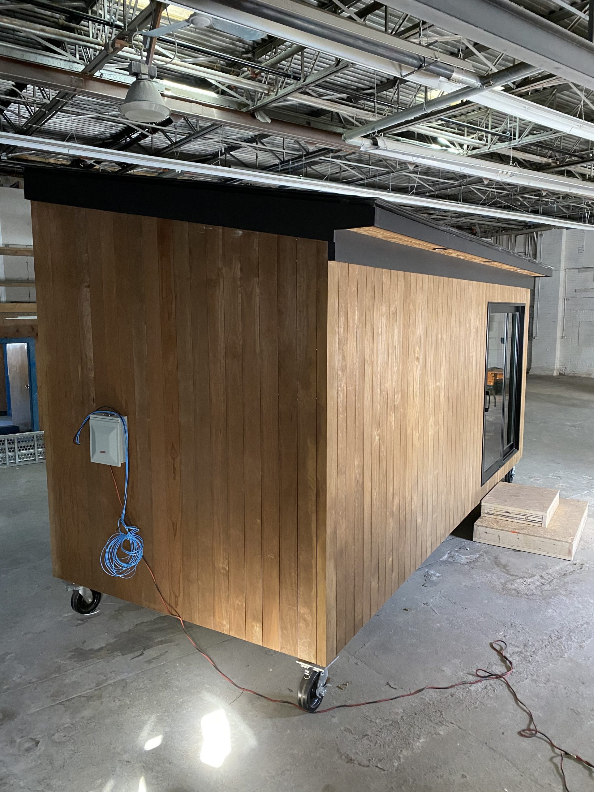 Three quarter view of an ADDASPACE shipping container that has been transformed into simple modern living spaces using Kebony Modified Wood 