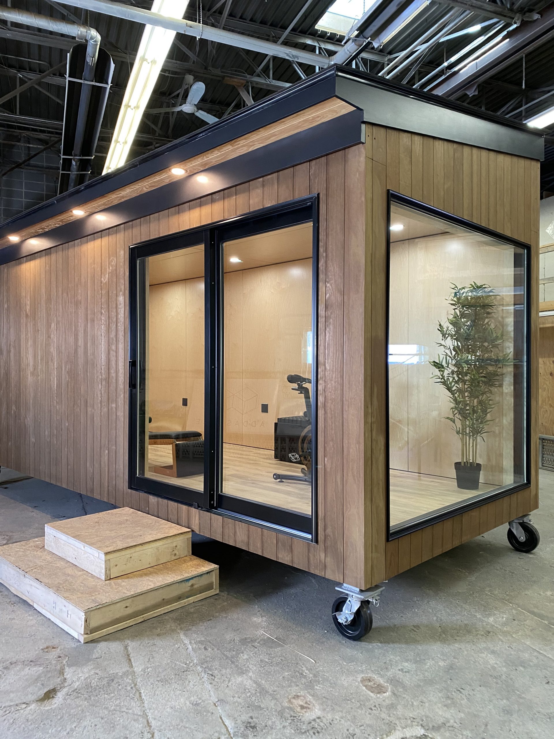 Three quarter view of an ADDASPACE shipping container that has been transformed into simple modern living spaces using Kebony Modified Wood 
