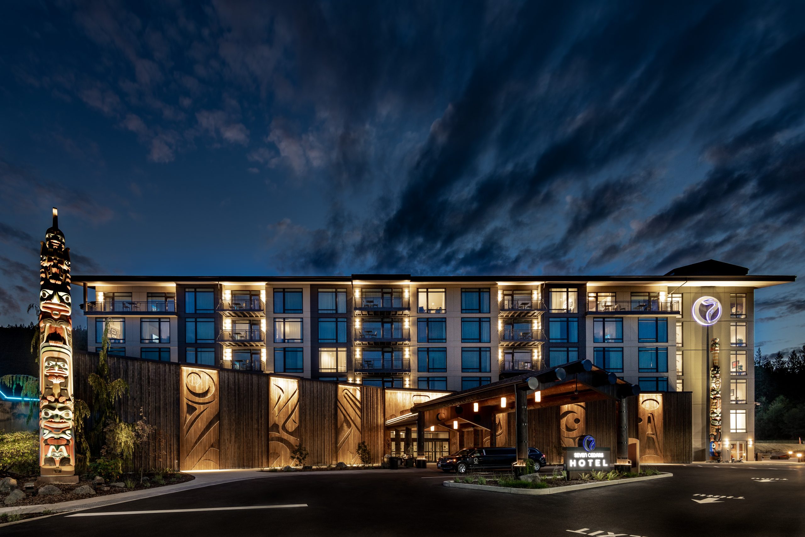 View of the front to the 7 Cedars Resort Hotel Casino in Sequim, Washington lit up at night featuring Kebony modified wood Clear and Character Cladding