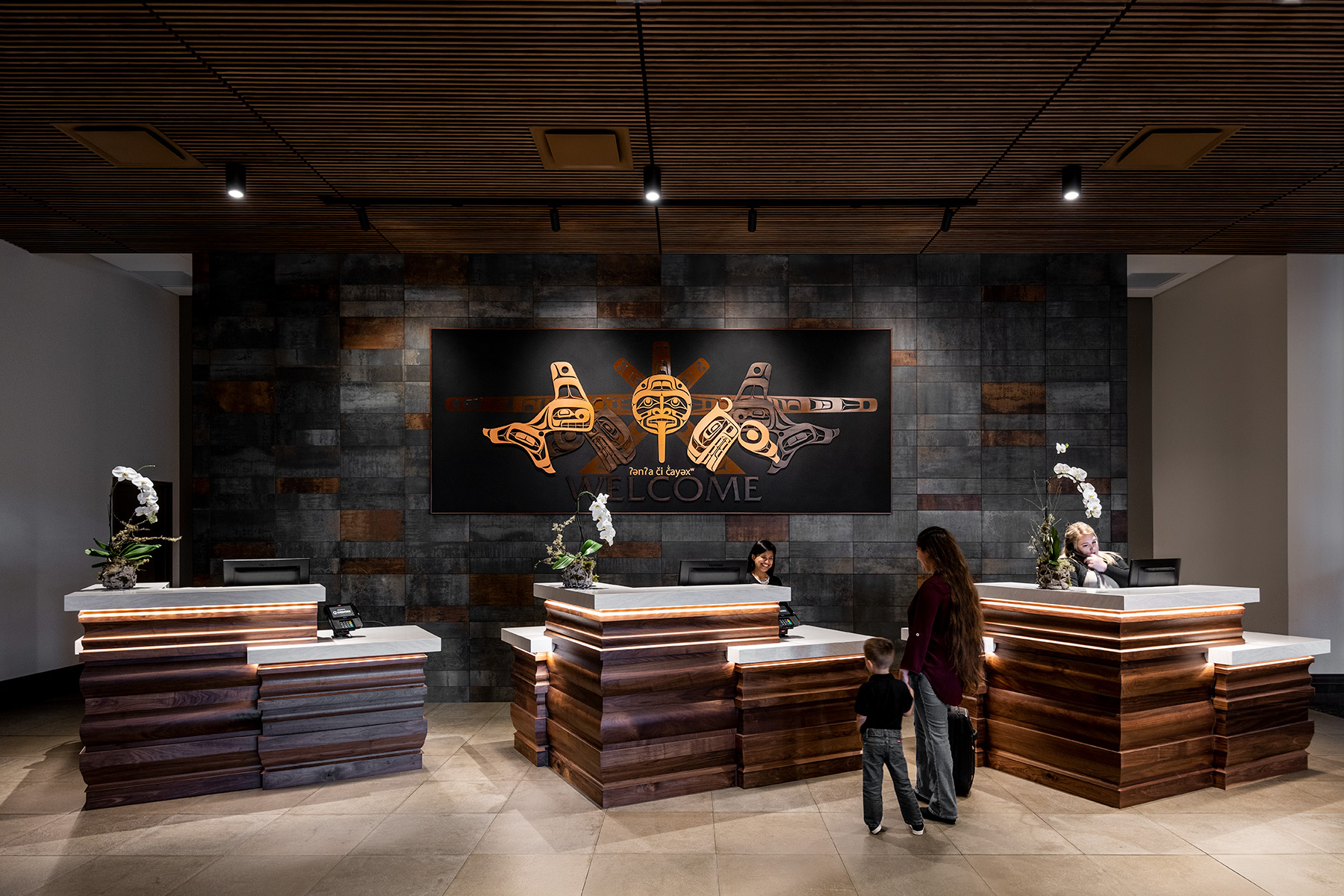 Inside the lobby a family is checking in for their reservation at the 7 Cedars Resort Hotel Casino in Sequim, Washington featuring Kebony modified wood Clear and Character Cladding