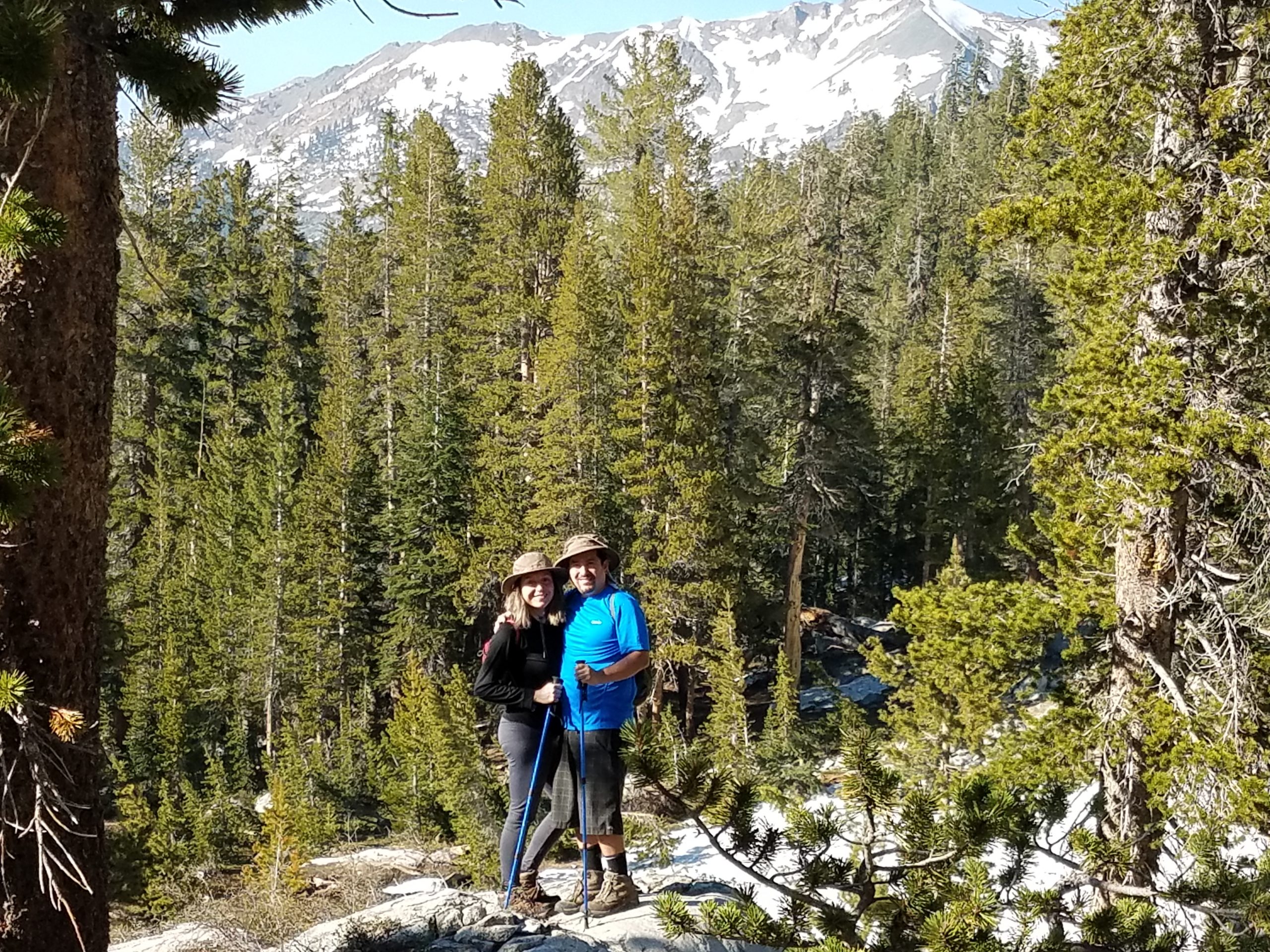 Judy Andrade, Business Development Specialist at Kebony, posing on a snowy wooded hiking trail with her fiancé during a sunny day