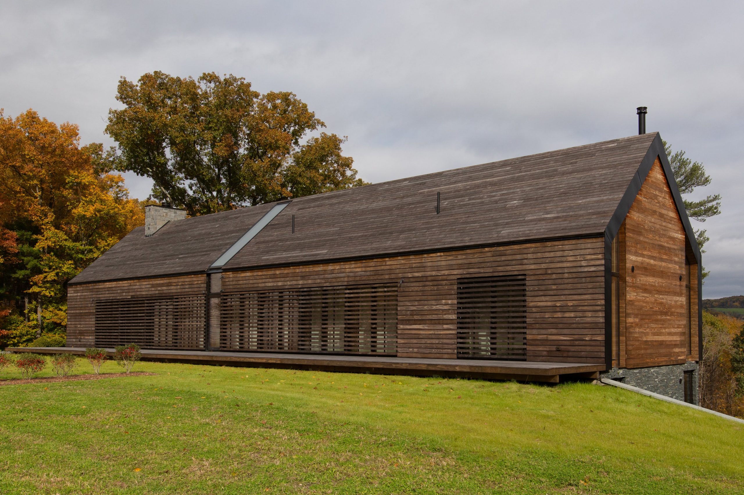 Side view of the modern Silvernail's Family House property featuring Kebony Modified Wood Clear Cladding located in Rhinebeck, New York on a sunny fall day