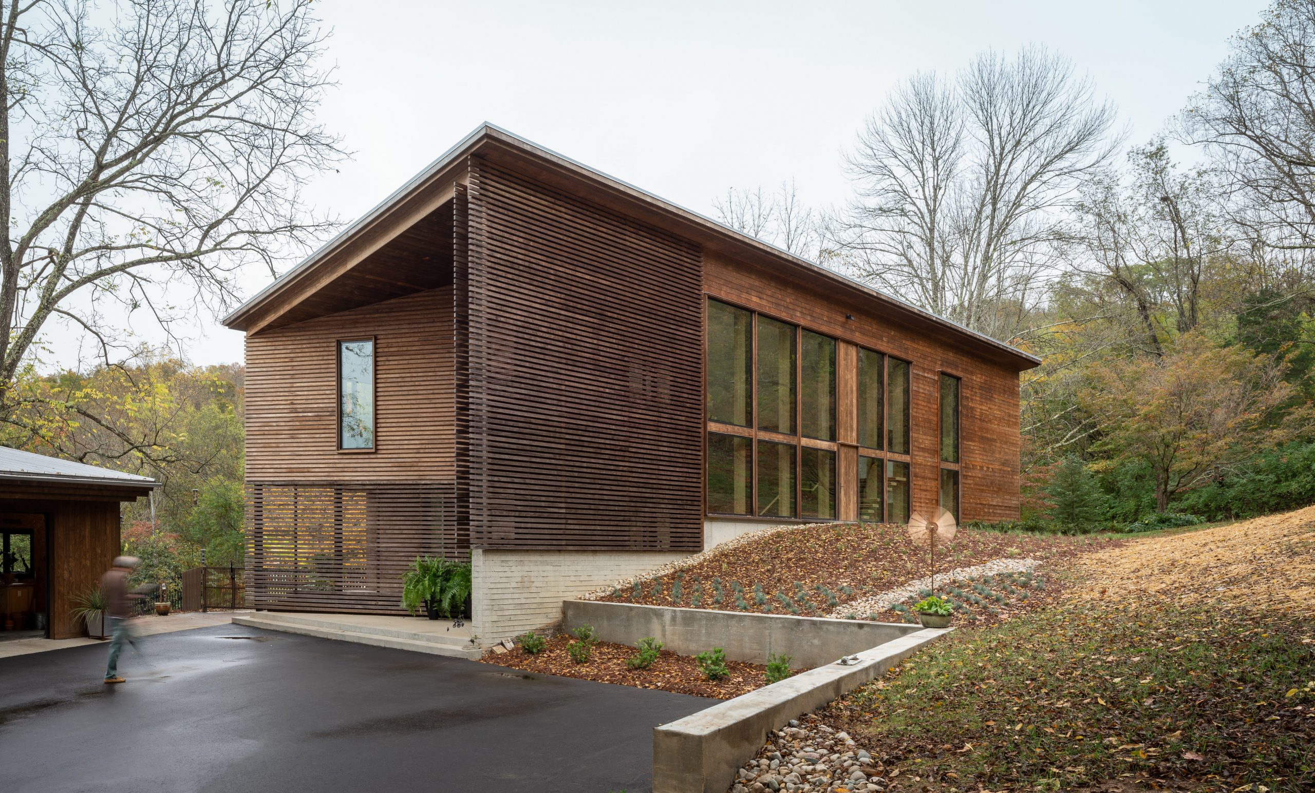 Three-quarter view of the Wood Screen House featuring Kebony Modified Wood Clear Cladding and the driveway in Nashville, Tennessee during an overcast day