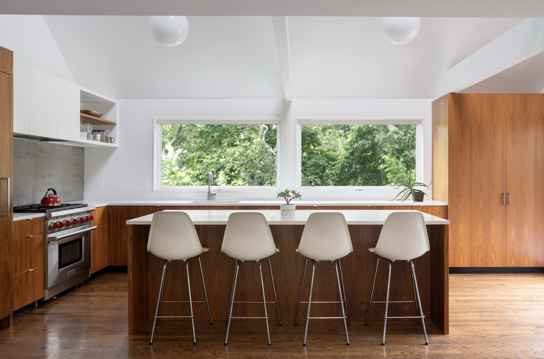 Interior view of the kitchen area with modern white furnishings and walls at Morris Island Residence on Morris Island in Chatham, Massachusetts featuring Kebony Modified Wood Clear Cladding throughout the design