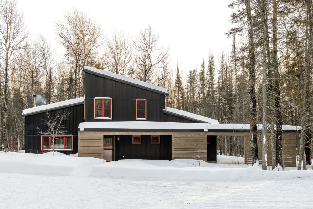 Knife River Cabin featuring Kebony Clear Cladding (Soffit and Slats) Modified Wood in Minneapolis Minnesota laden with snow in the woods.